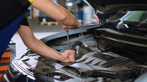 Midsection of man repairing car