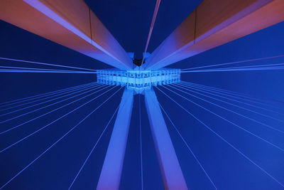 Low angle view of illuminated ferris wheel against blue sky