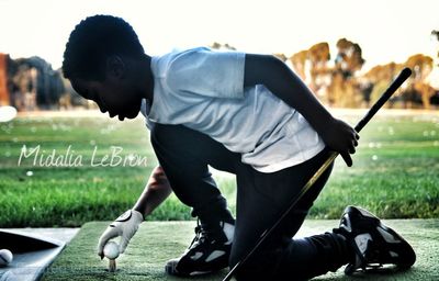 Young man playing on grass in park