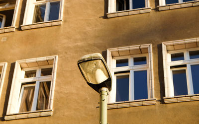 Low angle view of streetlight by building with closed window