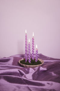 Pink candles on satin fabric