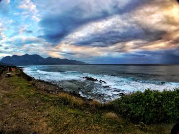 Scenic view of beach against dramatic sky