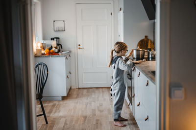 Smiling girl cooking in kitchen