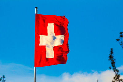Switzerland national flag waving on blue sky background. swiss confederation, ch