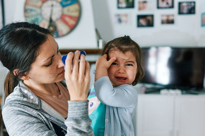 Brunette woman with child crying in her arms