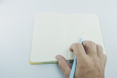 Close-up of hand writing in book