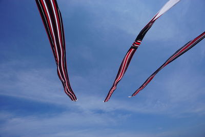 Low angle view of kites flying against sky