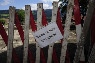 Close-up of text on wooden fence on field