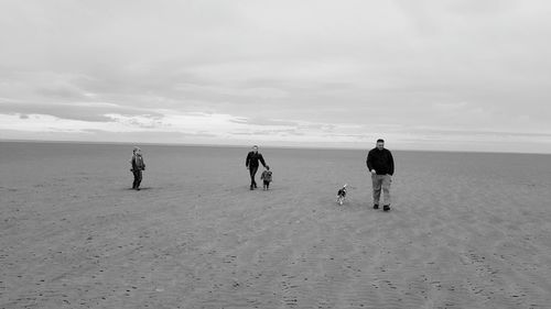 Full length of family with dog at beach