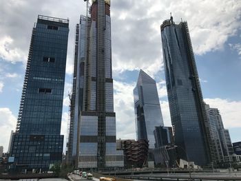 Low angle view of buildings against cloudy sky