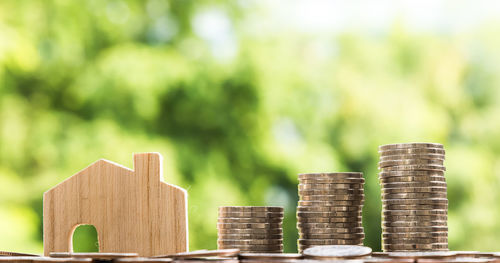 Close-up of wooden house with coins on table