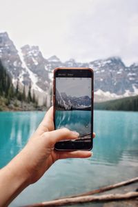 Hand holding mobile phone in water