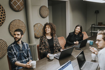 Smiling people sitting during business meeting