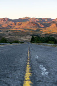 Road by mountains against sky