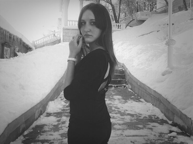 PORTRAIT OF YOUNG WOMAN STANDING ON SNOW COVERED LANDSCAPE