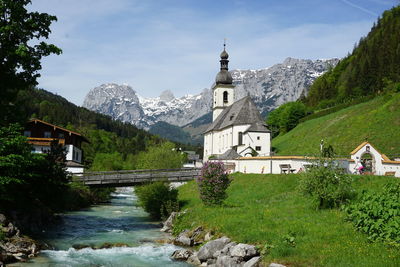 View of temple by building and mountains against sky