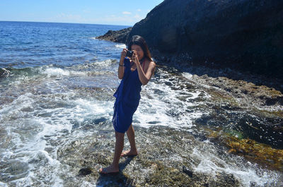 Full length of young woman standing on beach