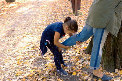 Rear view of two people standing by autumn leaves