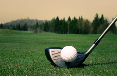 Golf ball with club on grass