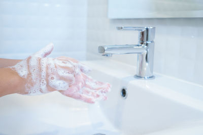 Midsection of woman in bathroom at home