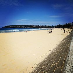 Scenic view of beach against blue sky