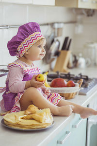 High angle view of cute baby girl sitting on table