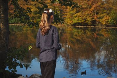 Rear view of girl standing against lake