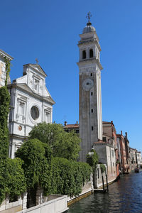 Church by building against clear blue sky