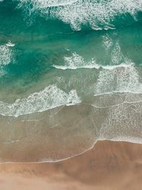 High angle view of waves rushing towards shore