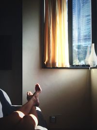 Low section view of person relaxing on sofa