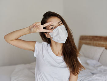 Midsection of woman holding hands on bed at home