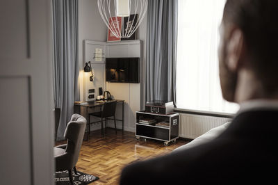 Rear view of businessman standing in hotel room