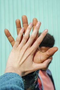 Hands of male and female friend giving high-five