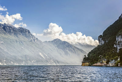 Scenic view of sea and snowcapped mountains against sky