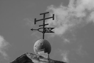 Low angle view of cross sculpture against sky