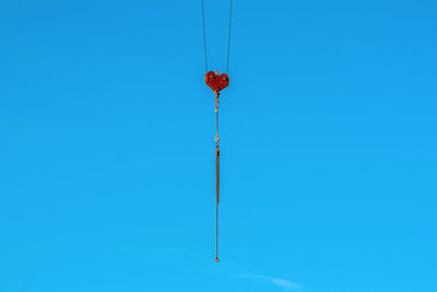 Low angle view of telephone pole against clear blue sky