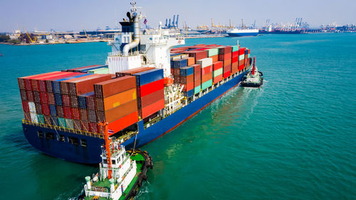 Container ship sailing in green sea and tugboat drag shipping to seaport at leam chabang chonburi 