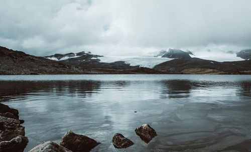 Scenic view of lake and snowcapped mountains against sky