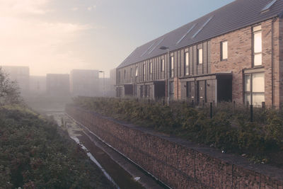 Railroad tracks by buildings in city against sky