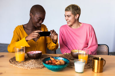 Side view of woman using mobile phone while sitting at home