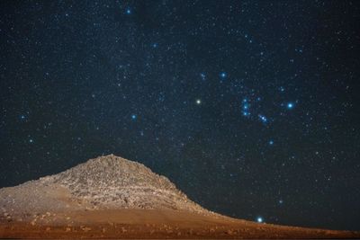 Scenic view of mountains against sky at night