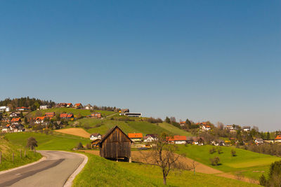 Houses on field against clear sky