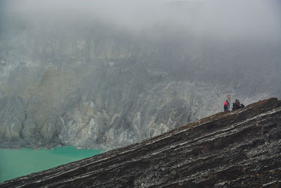 People on mountain against sky
