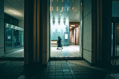 Lobby of an office building, with silhouette of a person walking through it