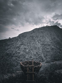 Low angle view of cross on mountain against sky