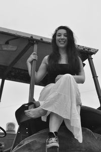 Portrait of smiling young woman against sky