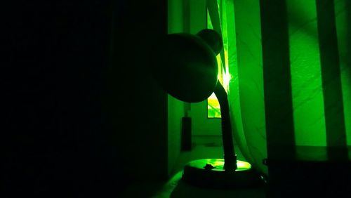 Silhouette person standing in illuminated dark room