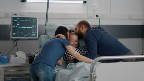Parents embracing daughter in hospital