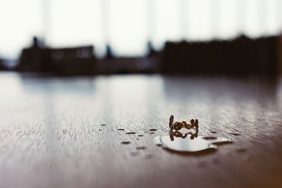 Surface level view of water drop by ring on wooden table