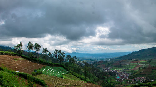 Scenic view of agricultural field against storm clouds
